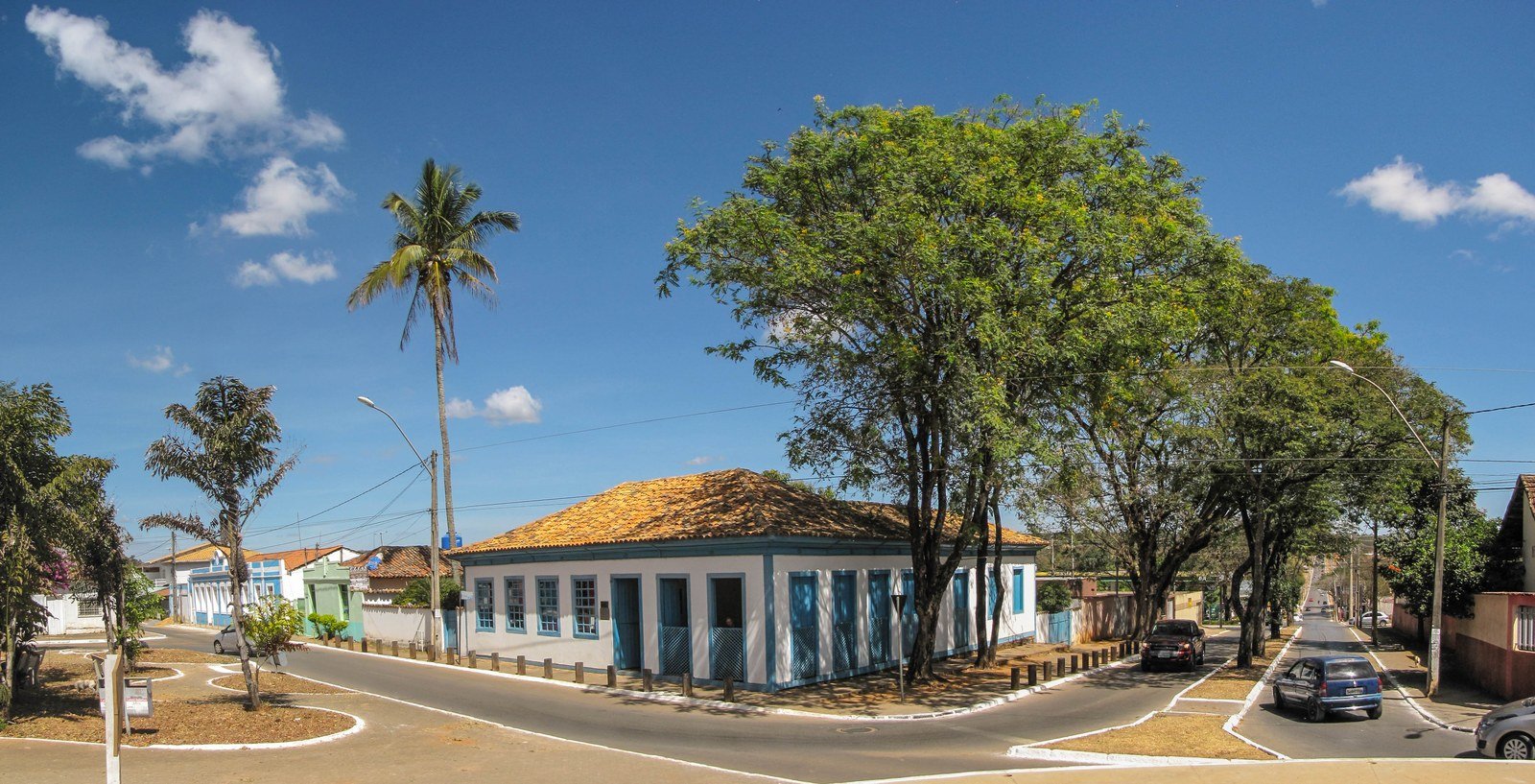 Casarão antigo de esquina, branco com esquadrias azuis e telhado de barro, no centro histórico de Planaltina