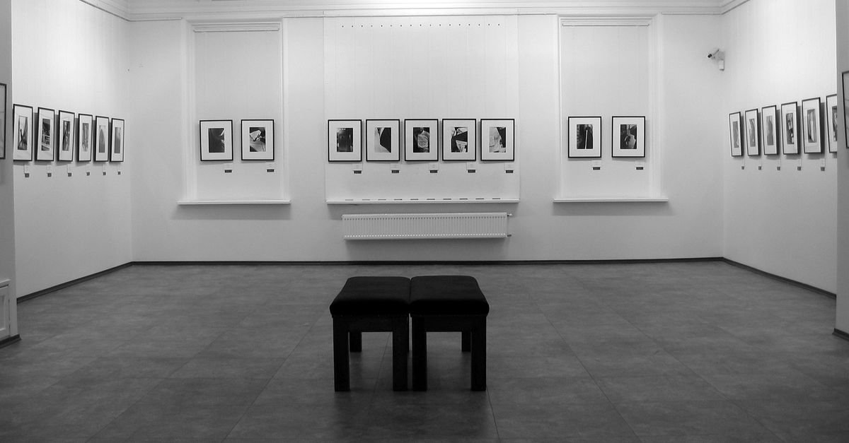 Sala de galeria de arte com obras emolduradas nas paredes brancas, imagem ilustrativa