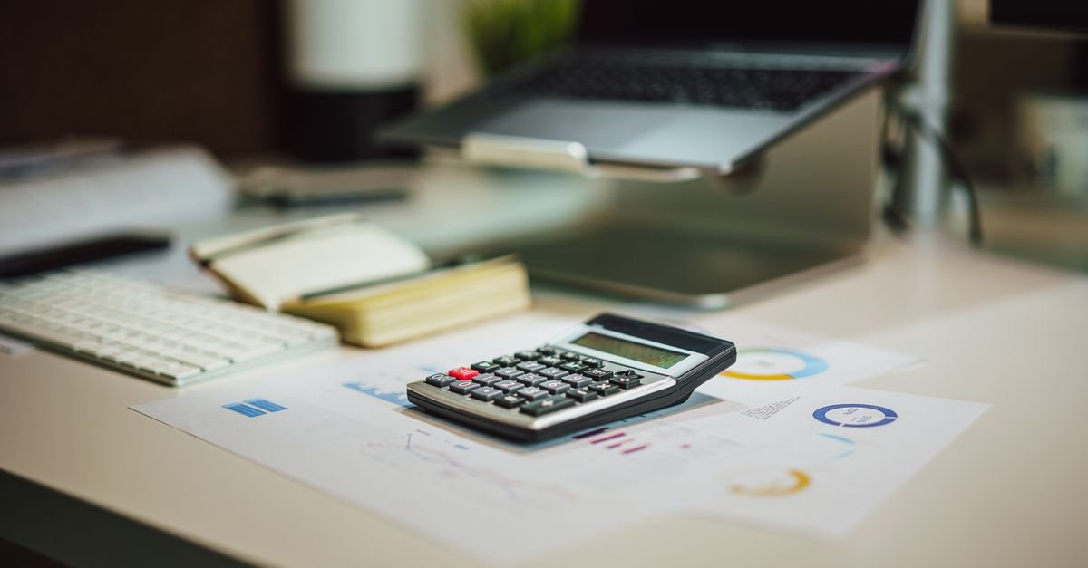 Calculadora sobre relatório com gráficos em mesa de escritório