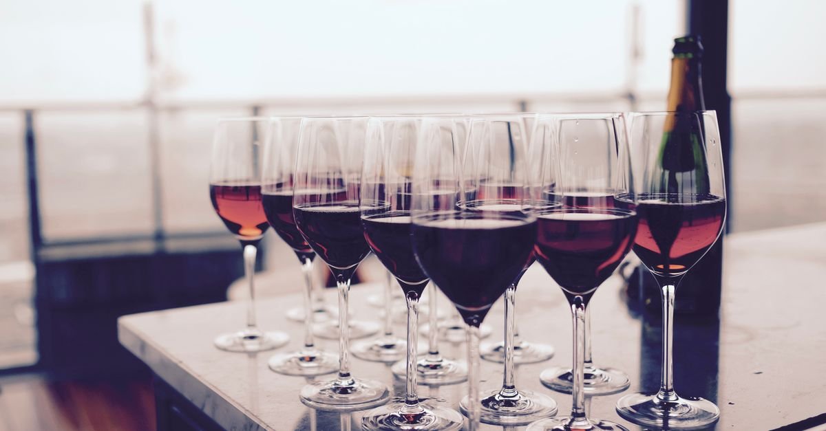 Taças de vinho tinto enfileiradas sobre uma mesa de degustação