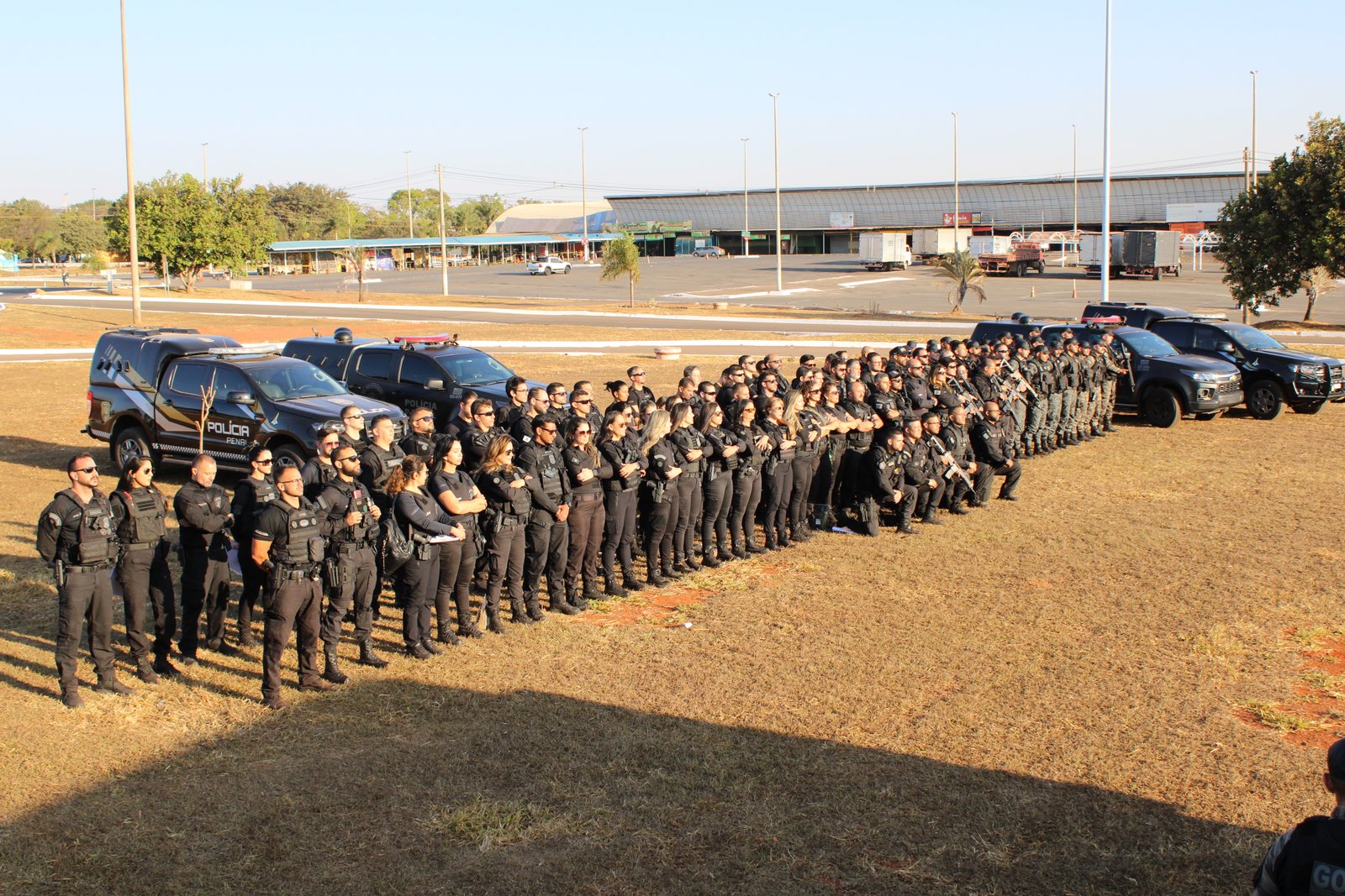 Agentes da Polícia Penal do Distrito Federal em formação ao lado de viaturas antes do início de operação