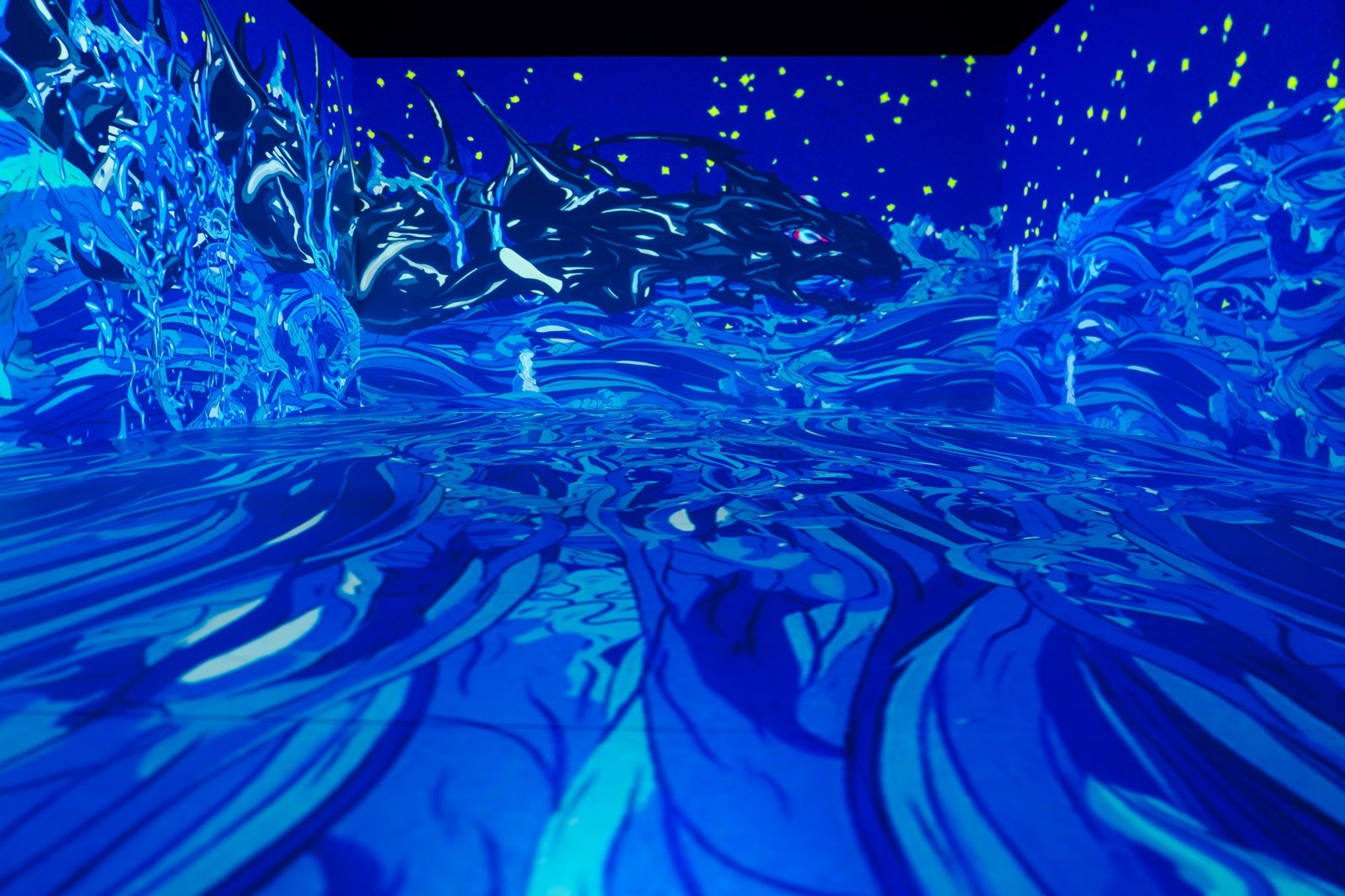Sala de projeção imersiva com criatura em tons de azul nas paredes e no piso, na mostra de Yoshitaka Amano no CCBB Brasília