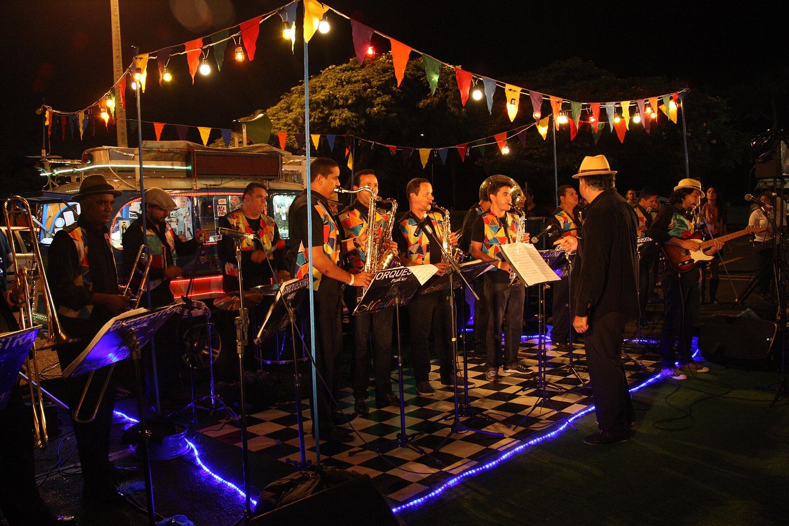 Banda toca sob bandeirinhas coloridas em festa noturna no Parque da Cidade