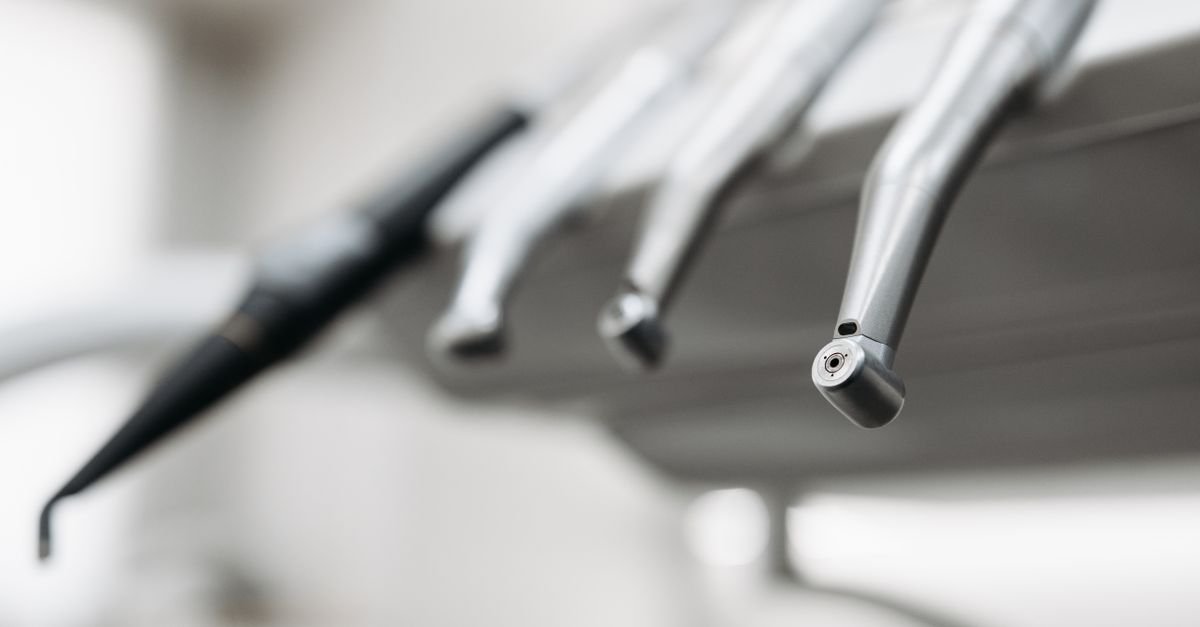 Instrumentos odontológicos de aço inoxidável apoiados em equipo de consultório