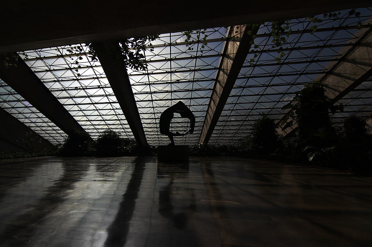 Interior do Teatro Nacional Cláudio Santoro, em Brasília, com a estrutura de vidro do foyer em contraluz