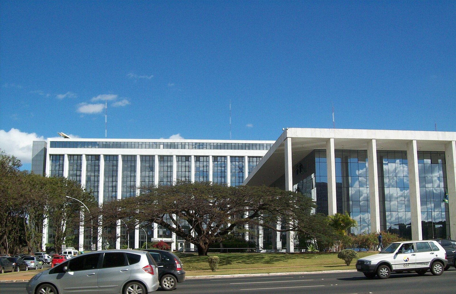 Fachada do Tribunal de Justiça do Distrito Federal e dos Territórios, em Brasília, com carros passando na via em frente