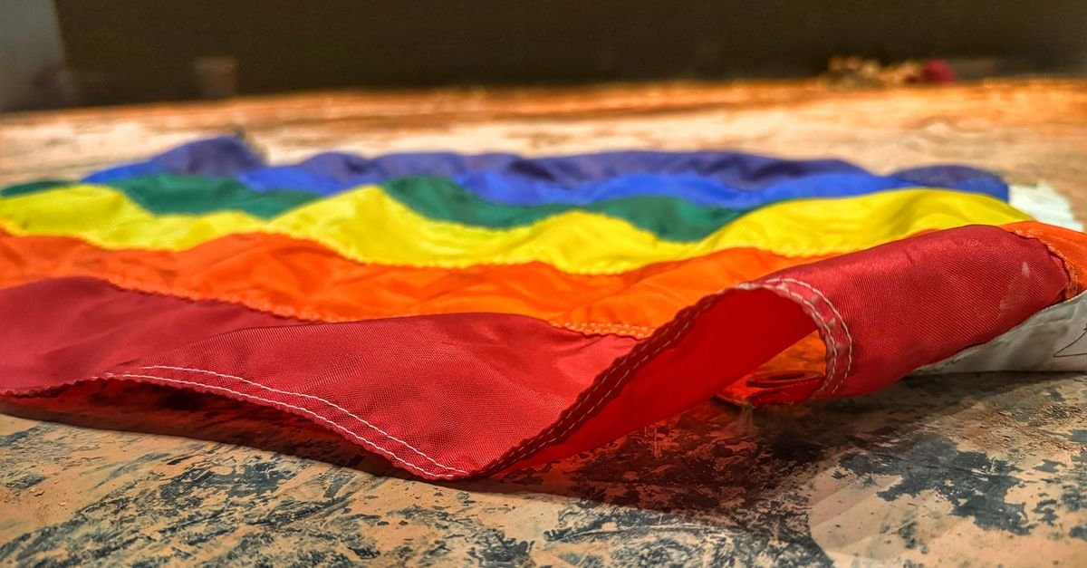 Bandeira do arco-íris dobrada sobre uma superfície, símbolo da causa LGBT