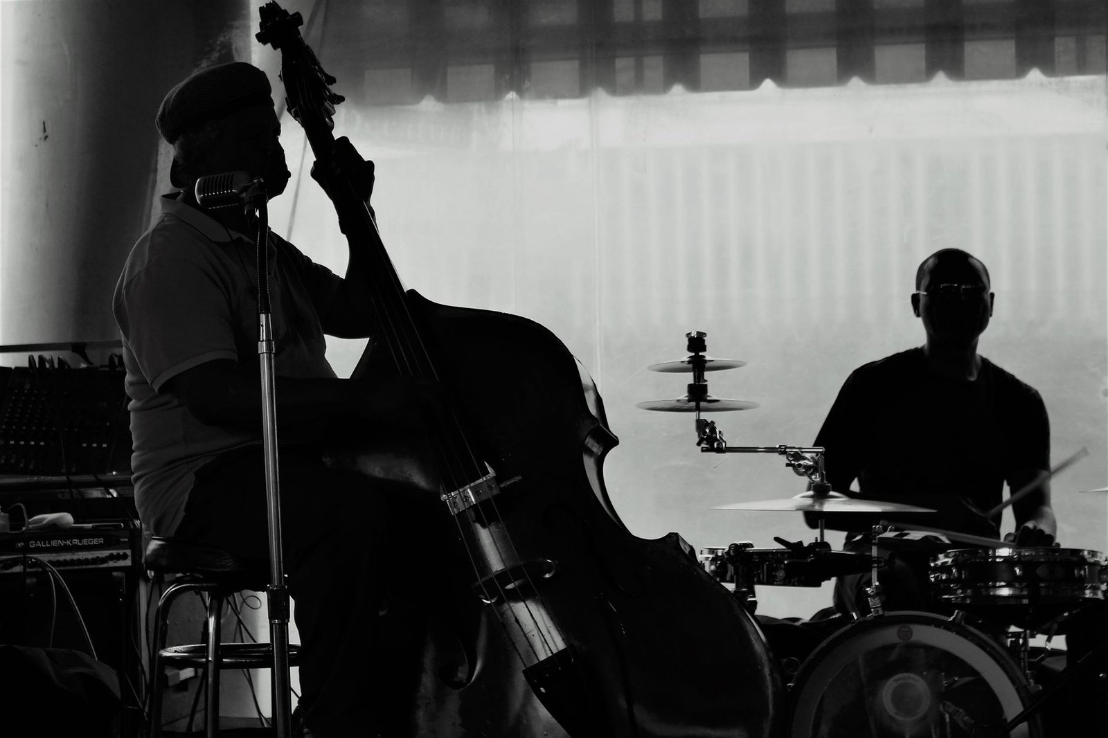 Silhueta de contrabaixista e baterista tocando jazz em um palco (foto de arquivo, ilustrativa)