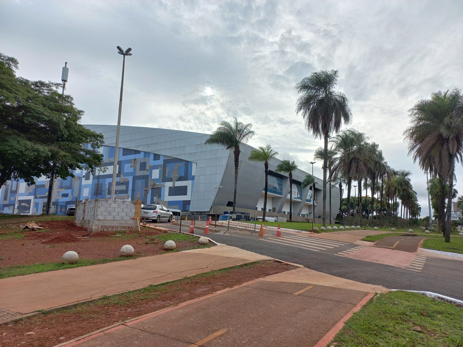 Lateral do Centro de Convenções Ulysses Guimarães, com o painel de azulejos azuis e as palmeiras da avenida
