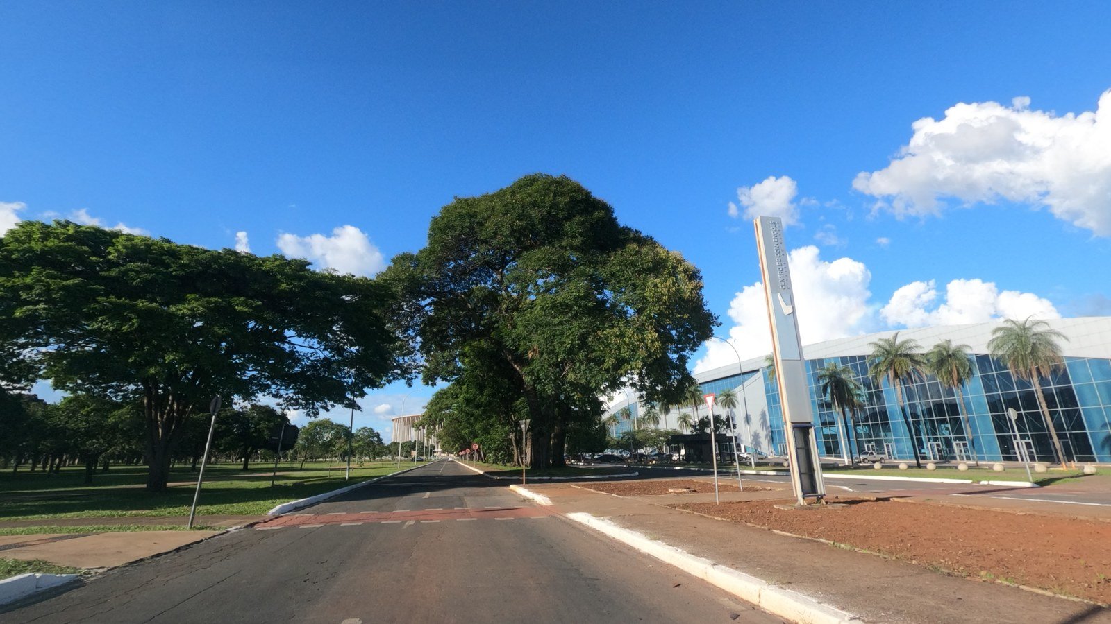Fachada envidraçada do Ulysses Centro de Convenções, em Brasília, vista da avenida em dia de céu azul