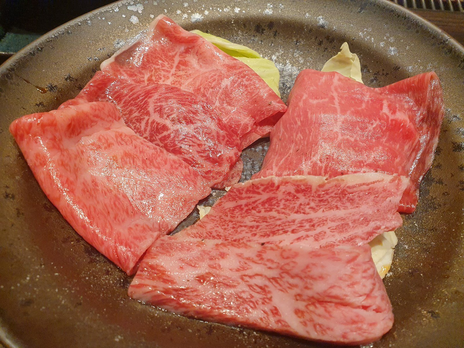Fatias de carne bovina marmorizada servidas para grelhar em restaurante de yakiniku